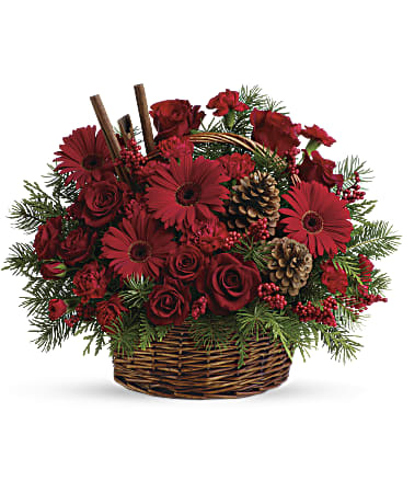 Red roses and gerbera daisies in a wicker basket with pinecones