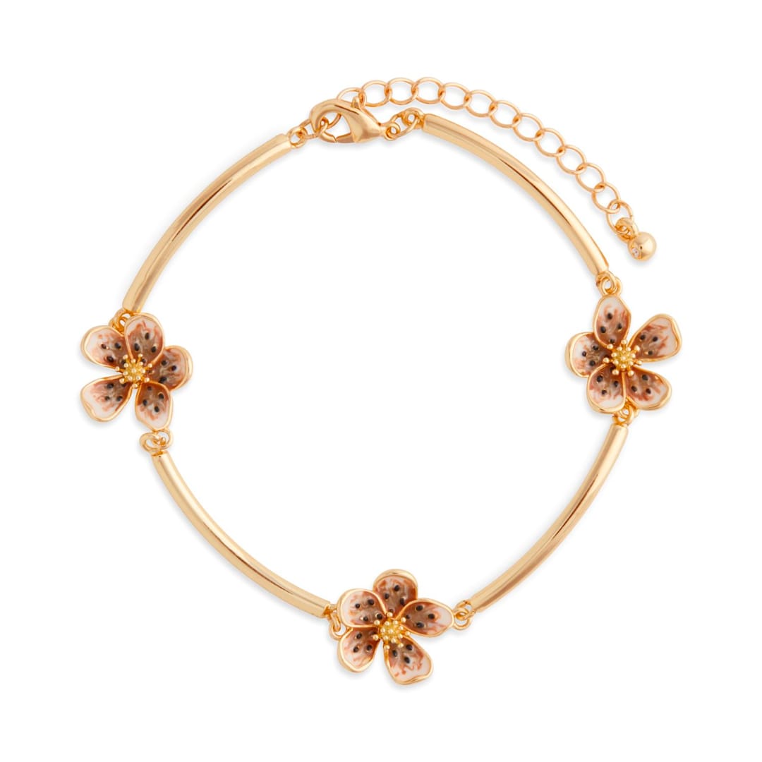 Gold bracelet with three flower charms on a white background