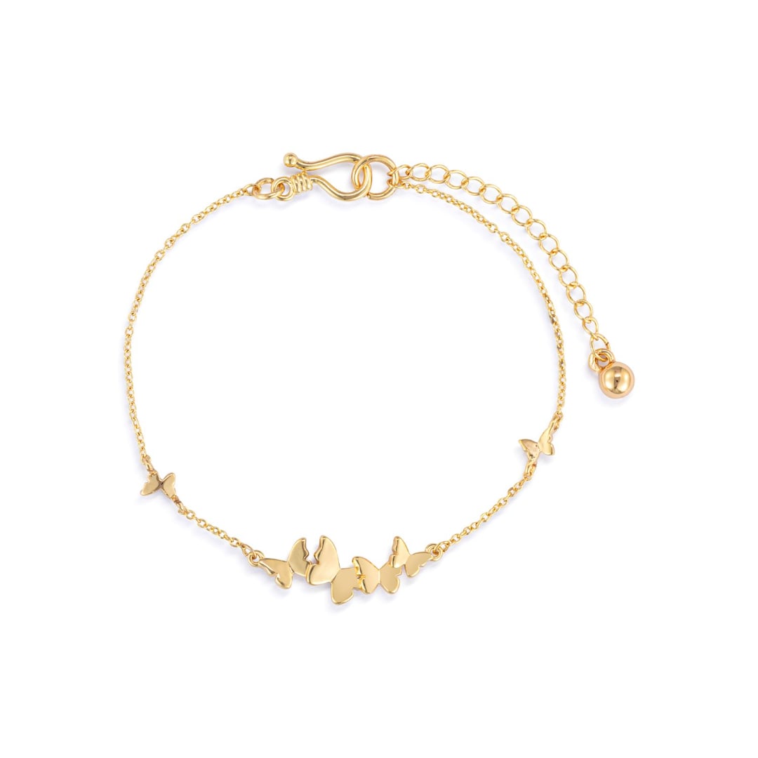 Gold butterfly charm bracelet on a white background
