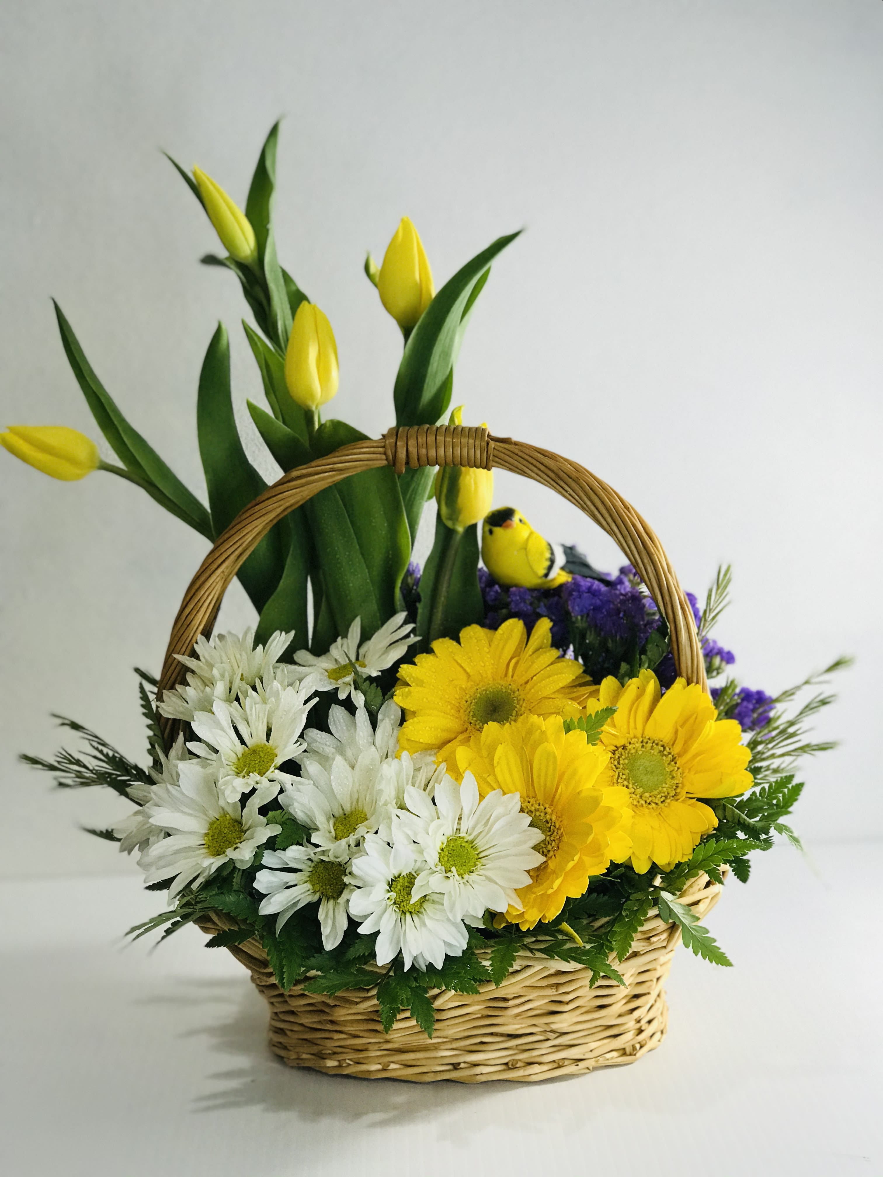 Basket arrangement with yellow tulips and white daisies