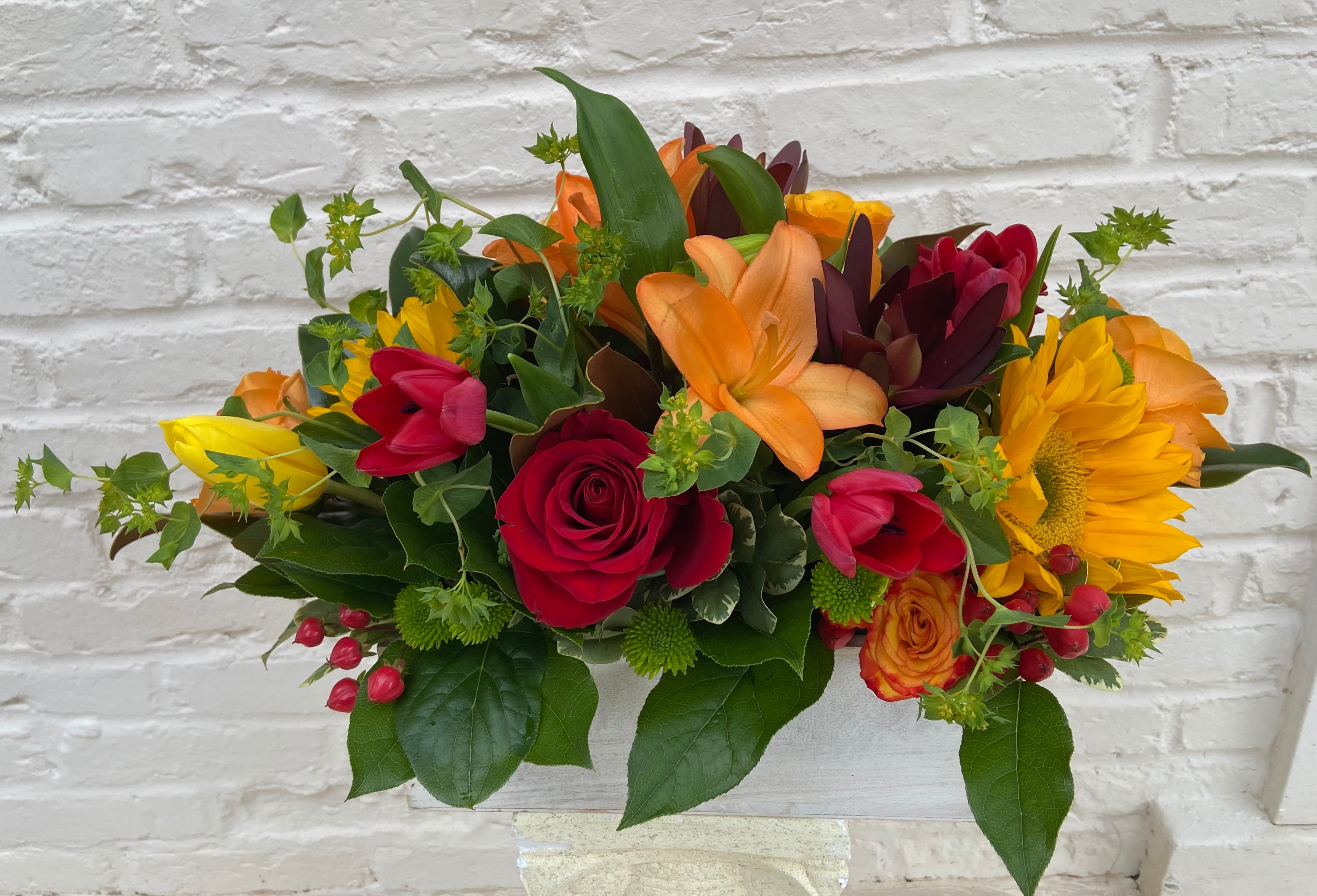 Colorful bouquet with roses, tulips, lilies, and a sunflower