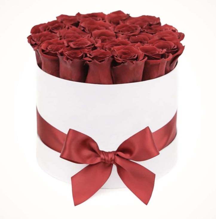 Round box of red roses with a red satin ribbon