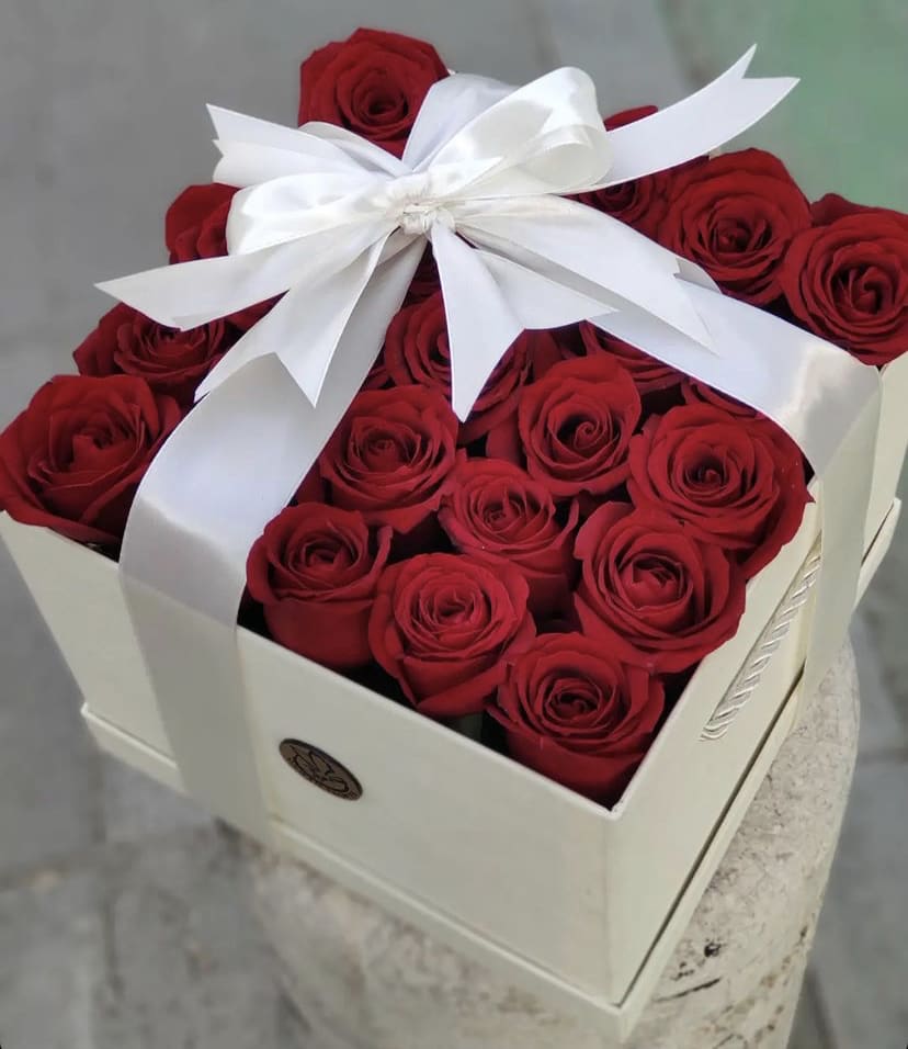 Box of red roses tied with a white ribbon