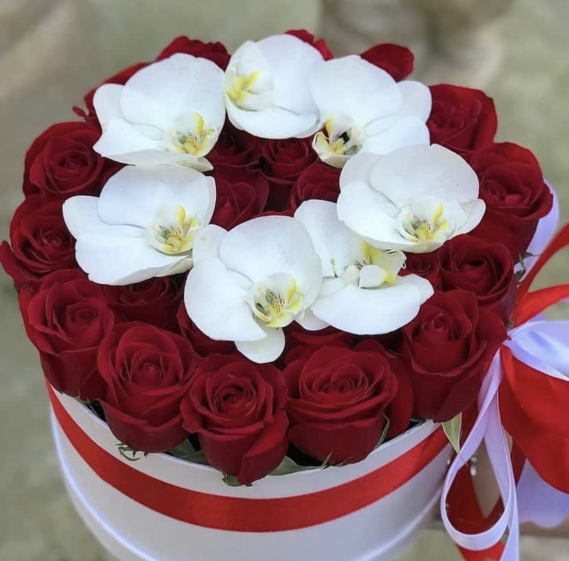 Red roses with white orchids in a round white box