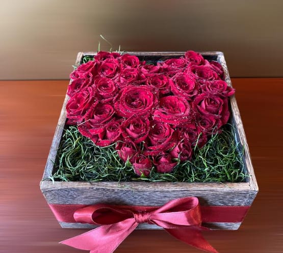 Heart-shaped box of red roses with a pink ribbon