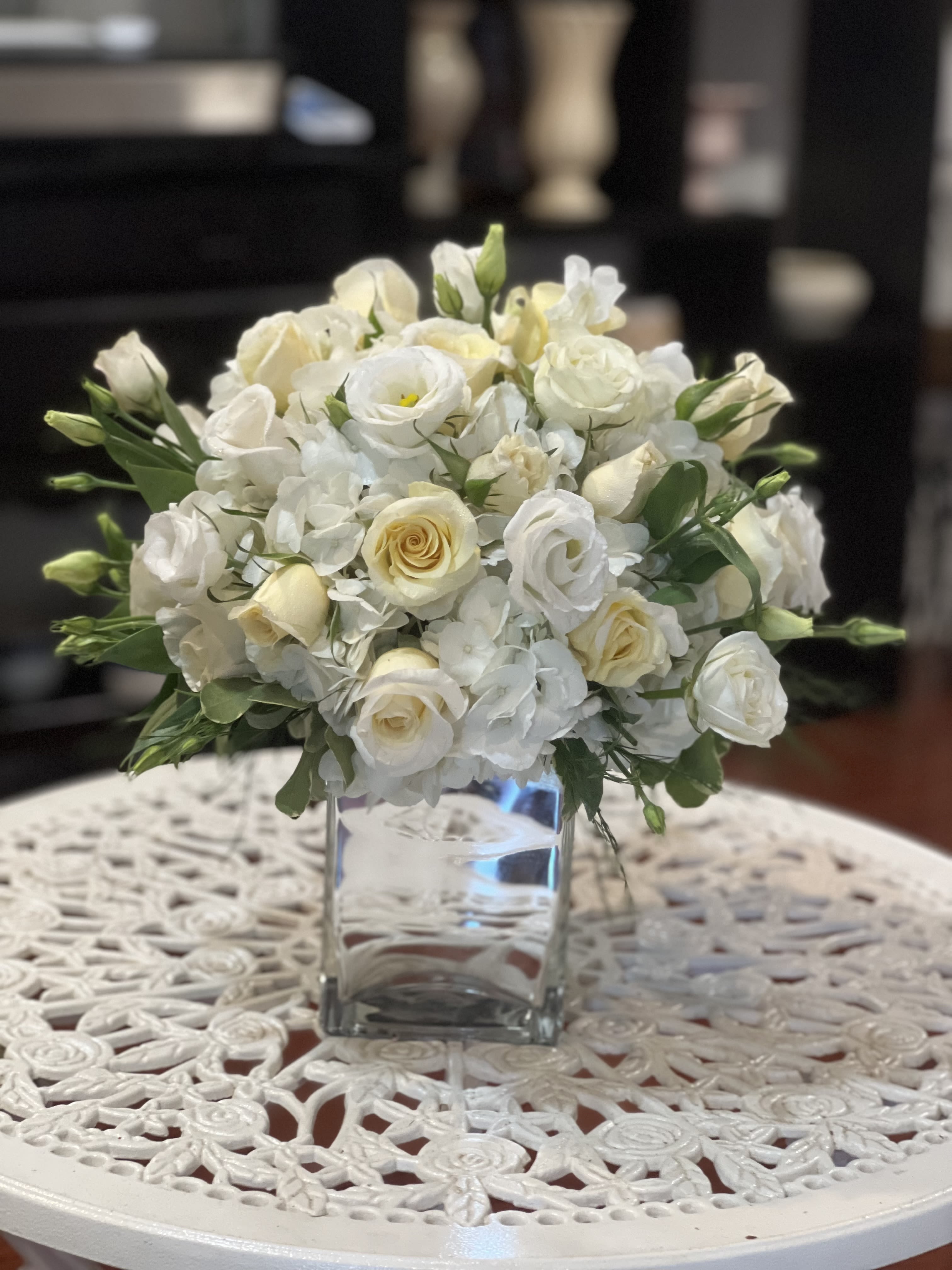 White rose and lisianthus bouquet in a clear glass vase