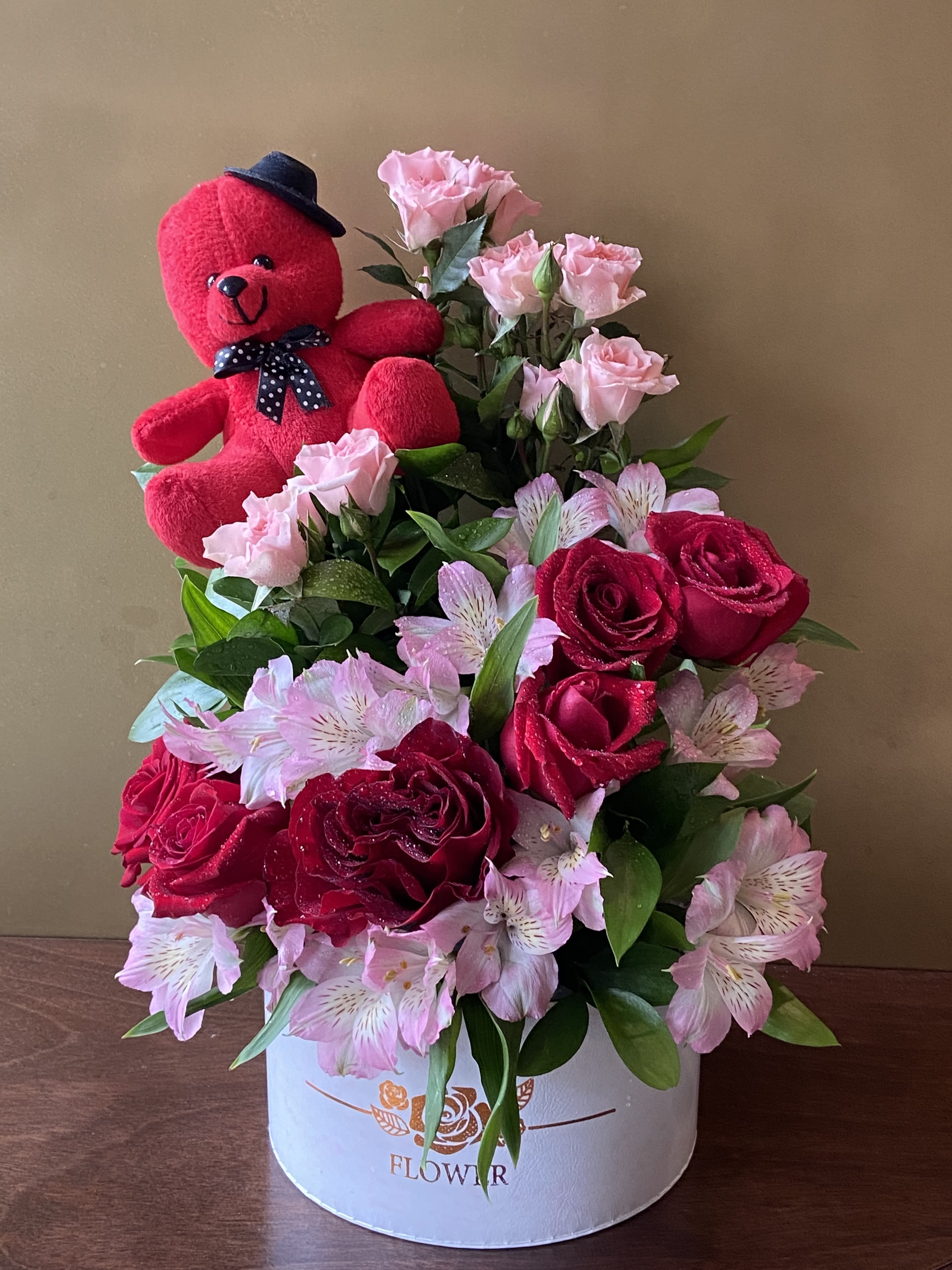 Red teddy bear with pink roses and red roses in a white box