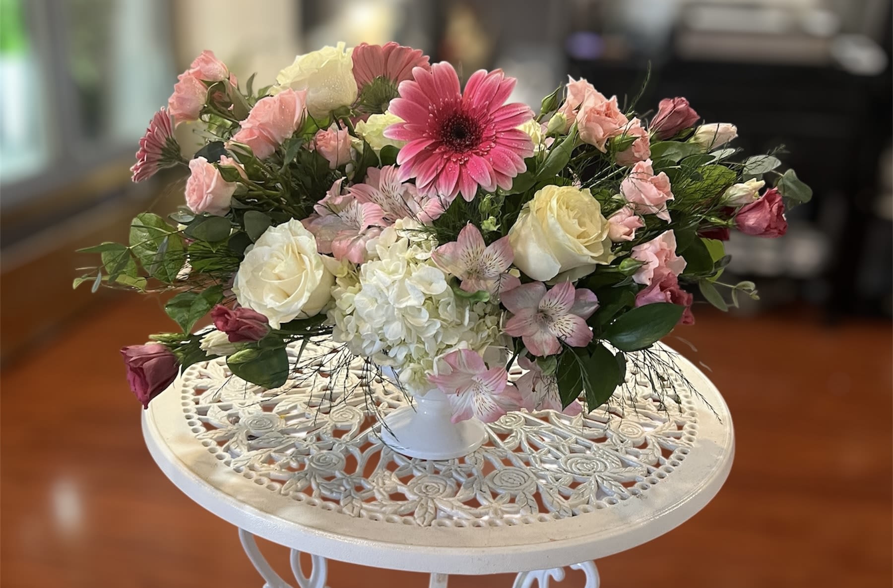 Pink and white mixed flower arrangement in a white vase