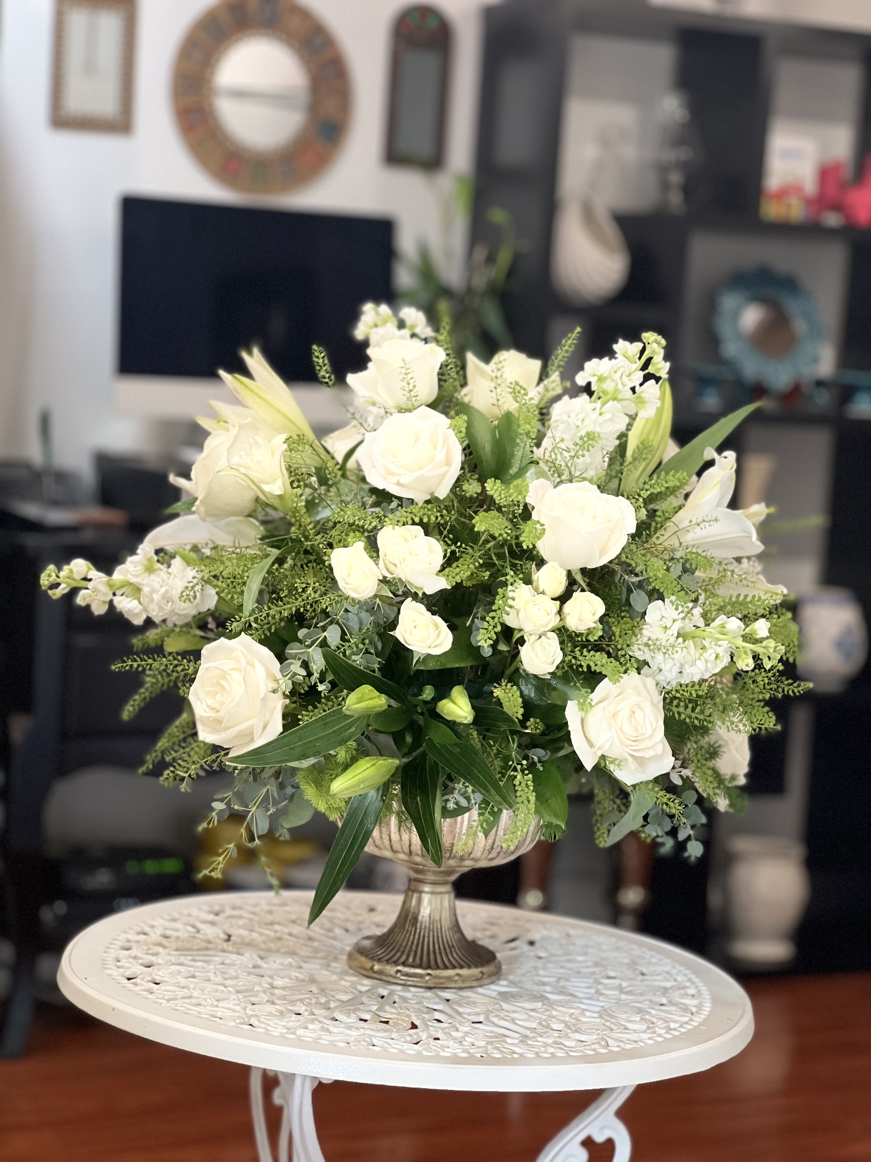 White rose arrangement in a silver pedestal vase