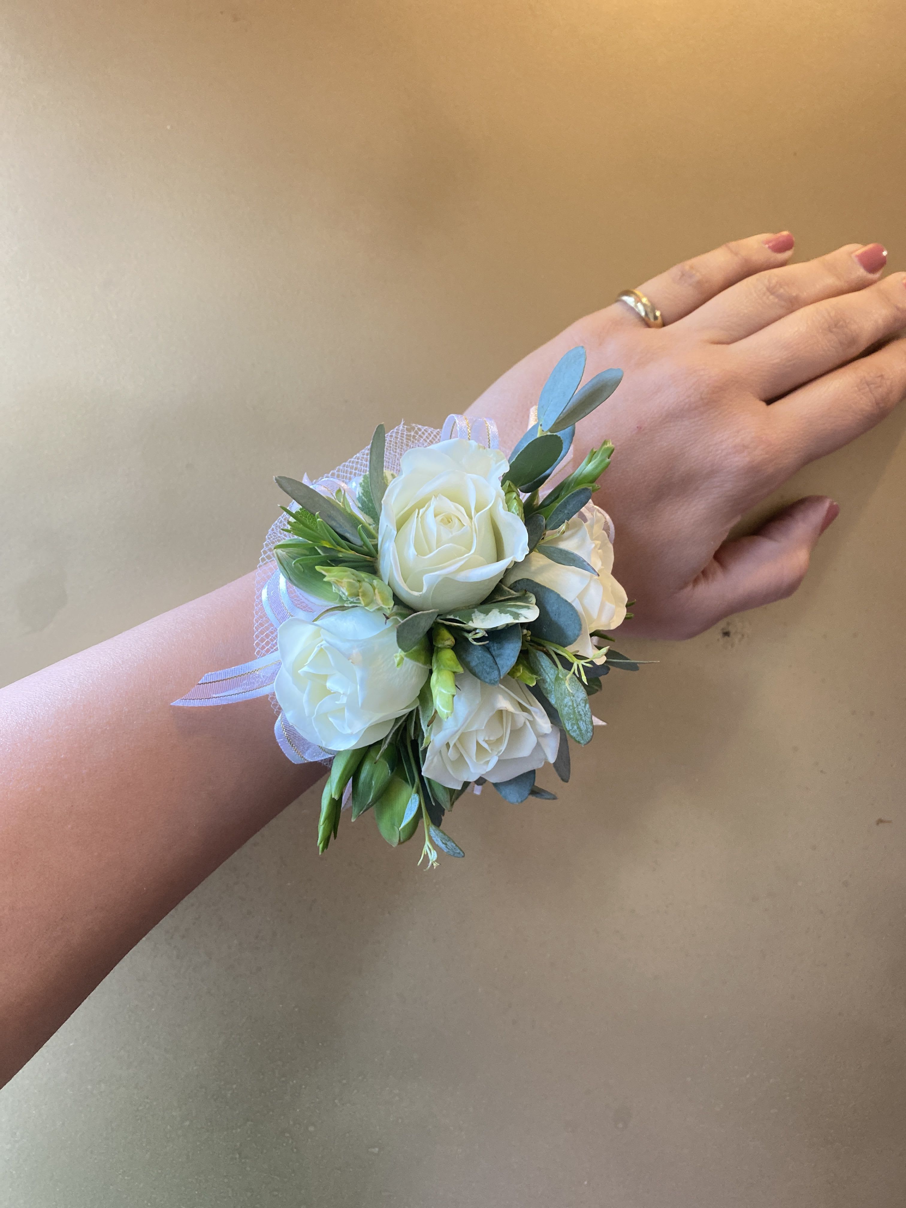 White rose wrist corsage with ribbon and greenery