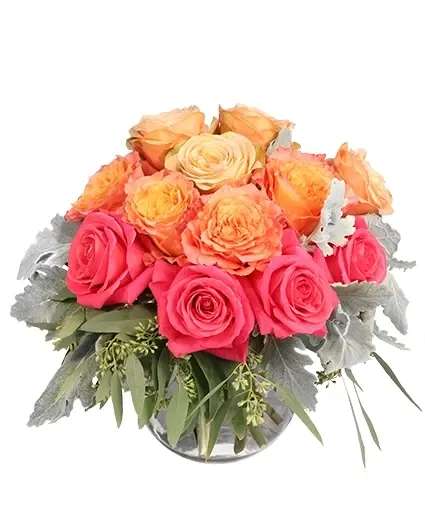 Pink and peach roses arranged in a clear glass vase
