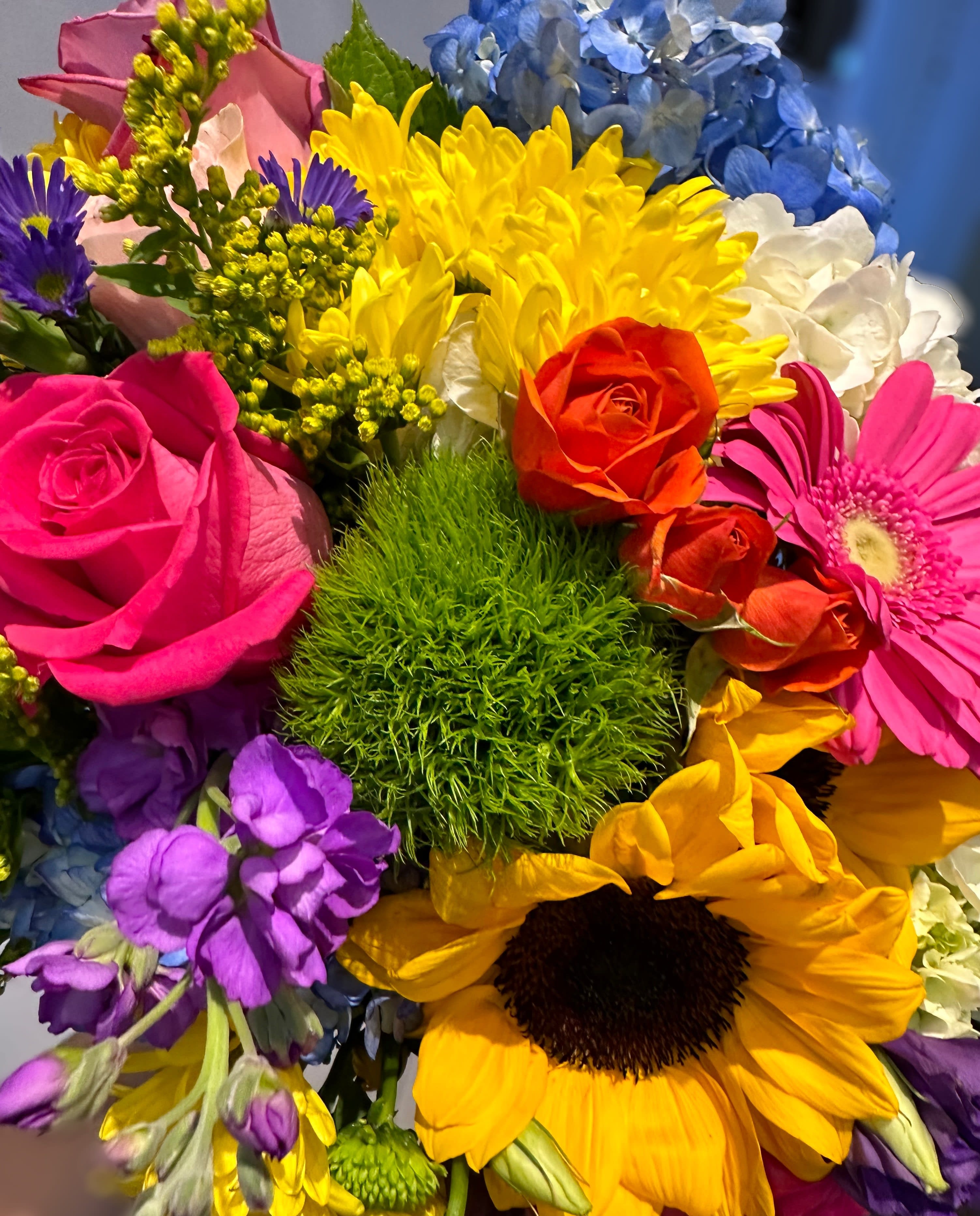 Colorful mixed bouquet with roses, sunflowers, and hydrangeas
