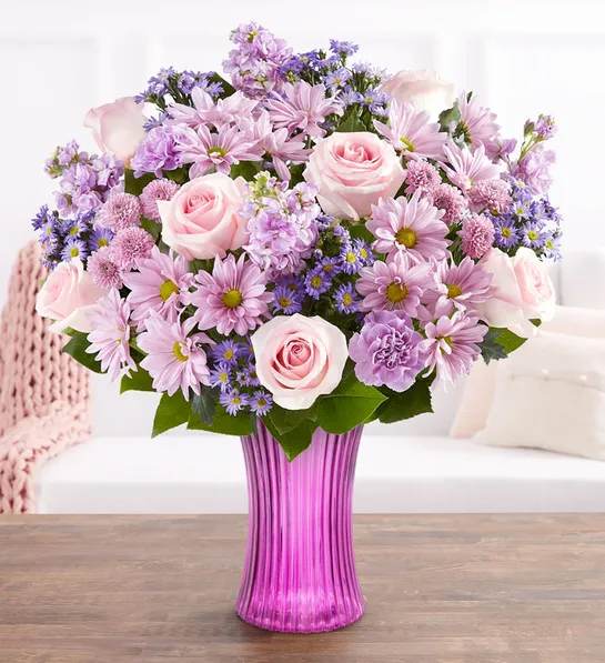 Pink and lavender mixed bouquet in a purple glass vase