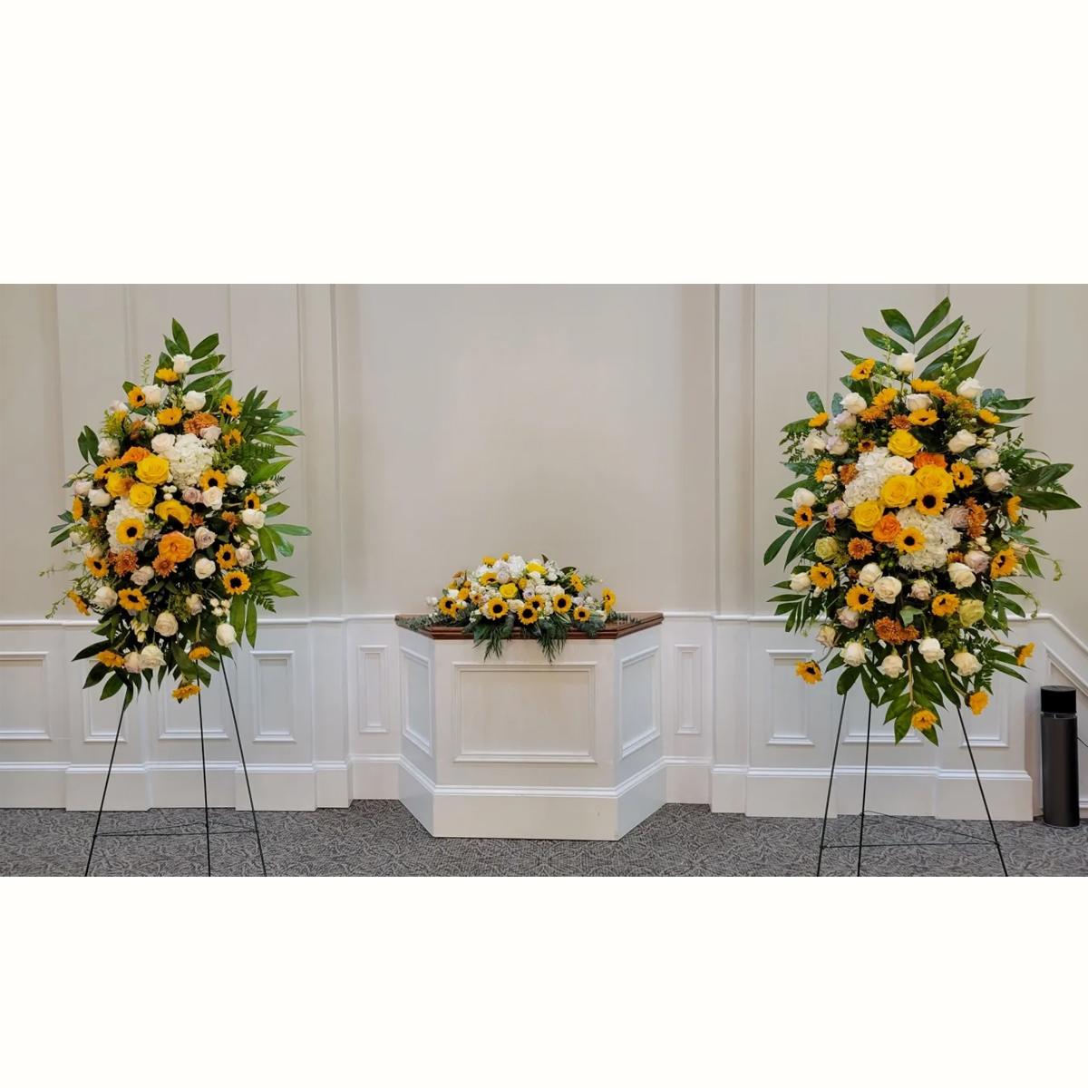 Set of yellow and white standing sprays with matching altar arrangement in a chapel setting