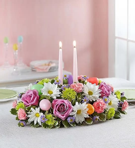 Low floral centerpiece with two pink candles and pastel flowers