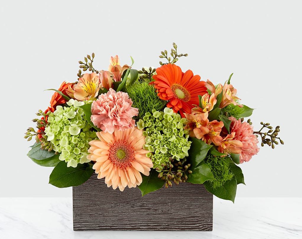 Mixed orange and peach flowers in a rectangular wooden box