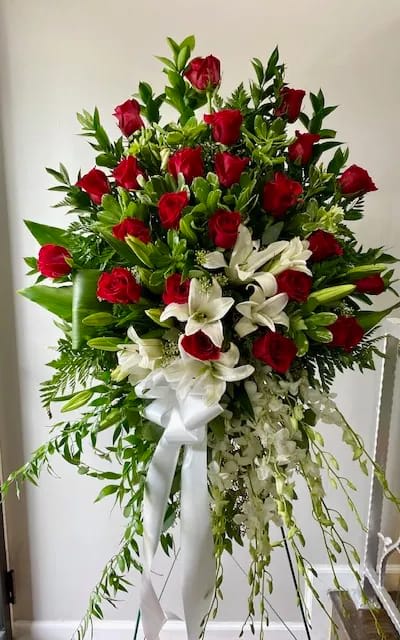 Standing spray of red roses and white lilies with a white ribbon
