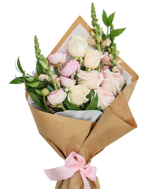 Bouquet of pale pink and cream roses wrapped in brown paper