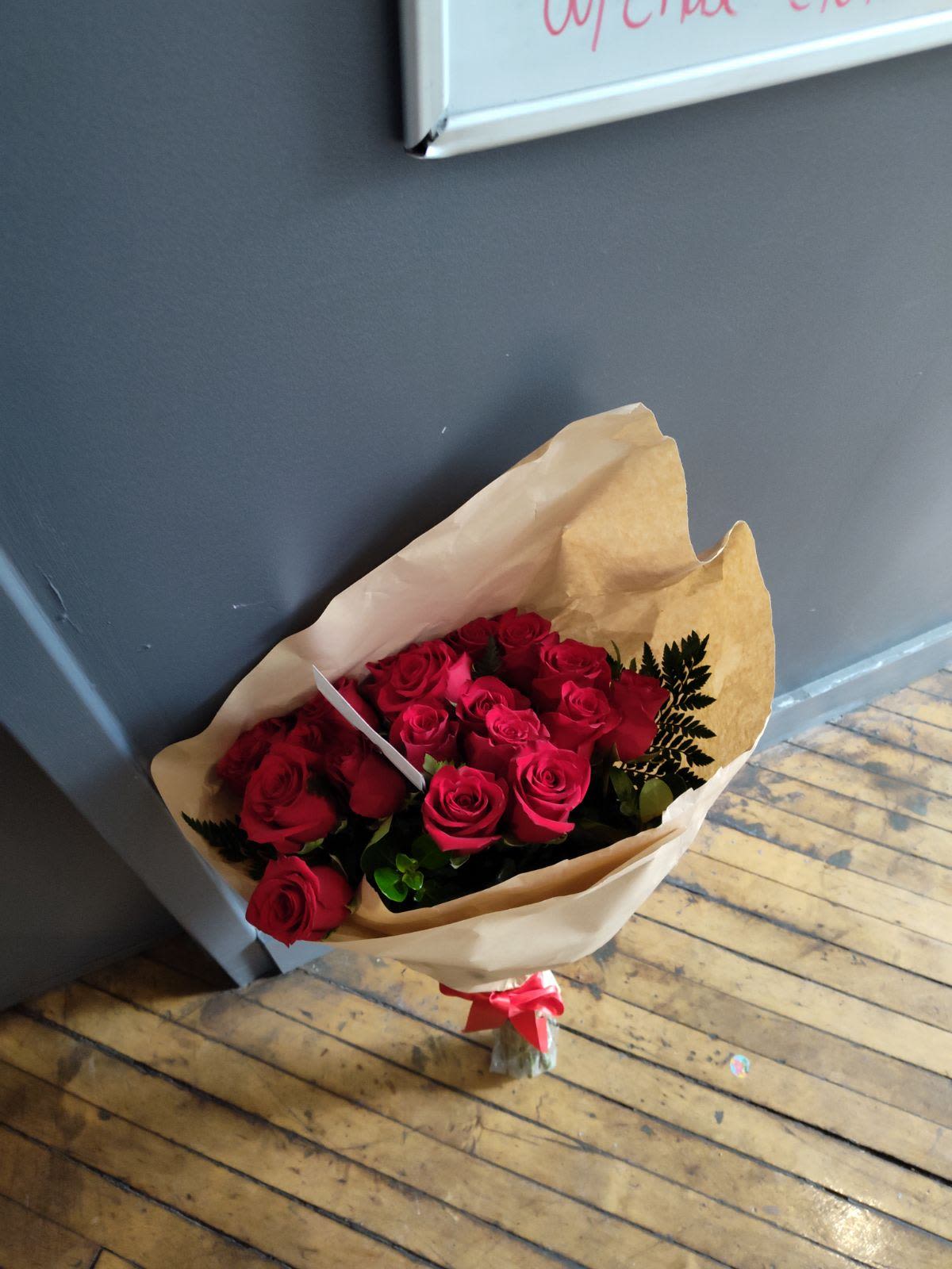 Bouquet of red roses wrapped in brown paper with a red ribbon