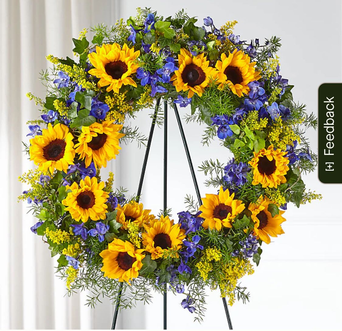 Sunflower wreath with blue flowers on a black stand