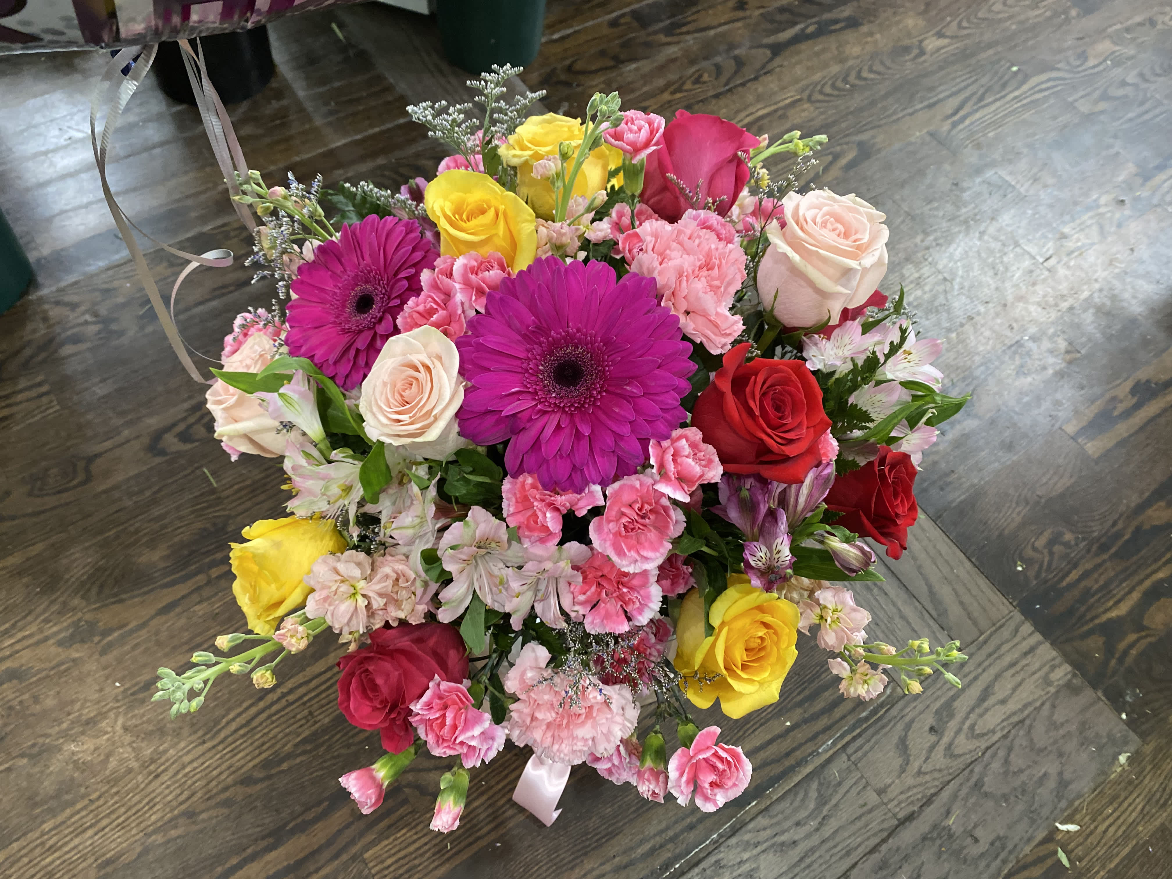 Mixed bouquet of roses, gerbera daisies, and carnations in pink, red, and yellow