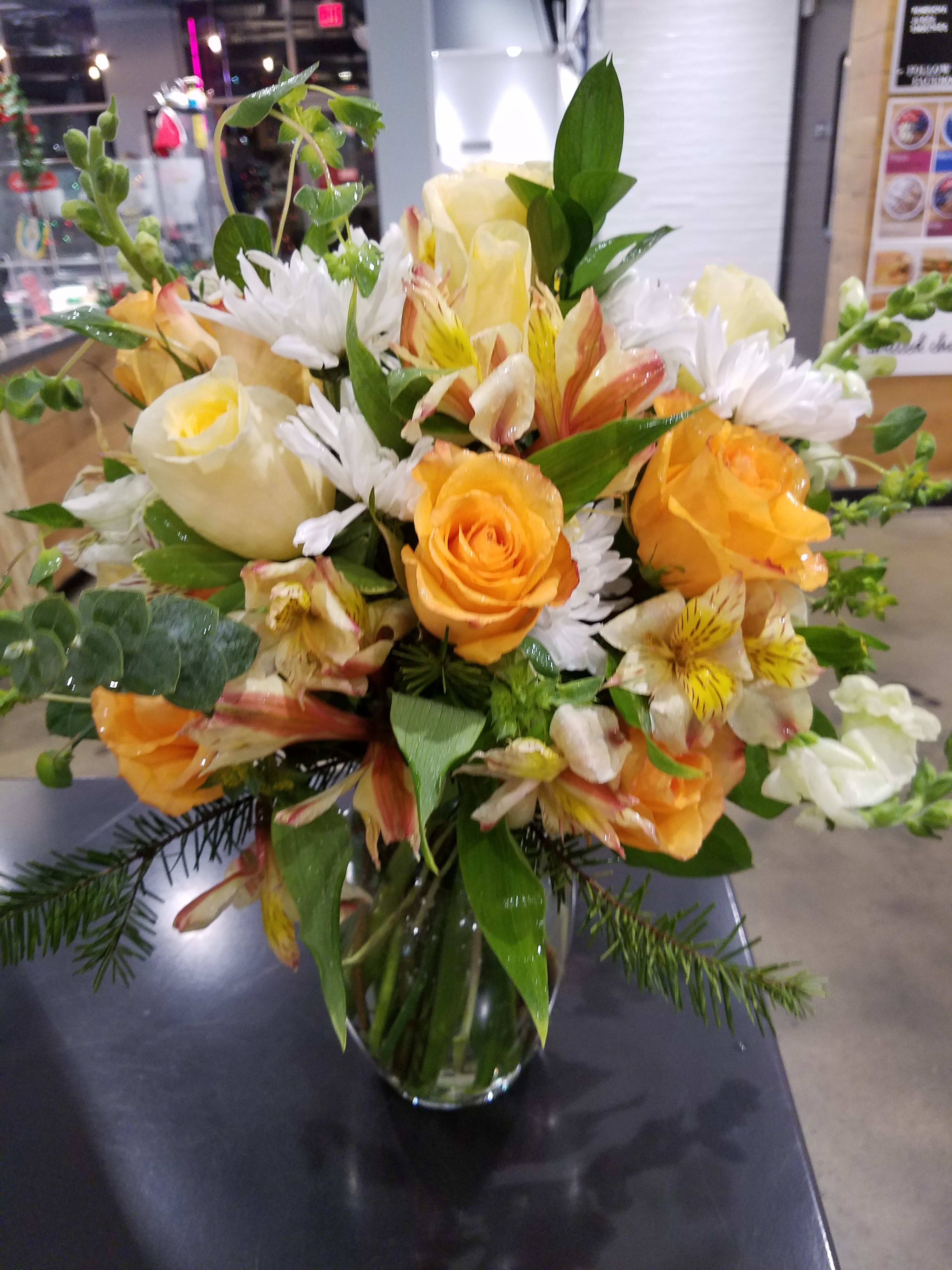 Bouquet of orange and white flowers in a clear glass vase