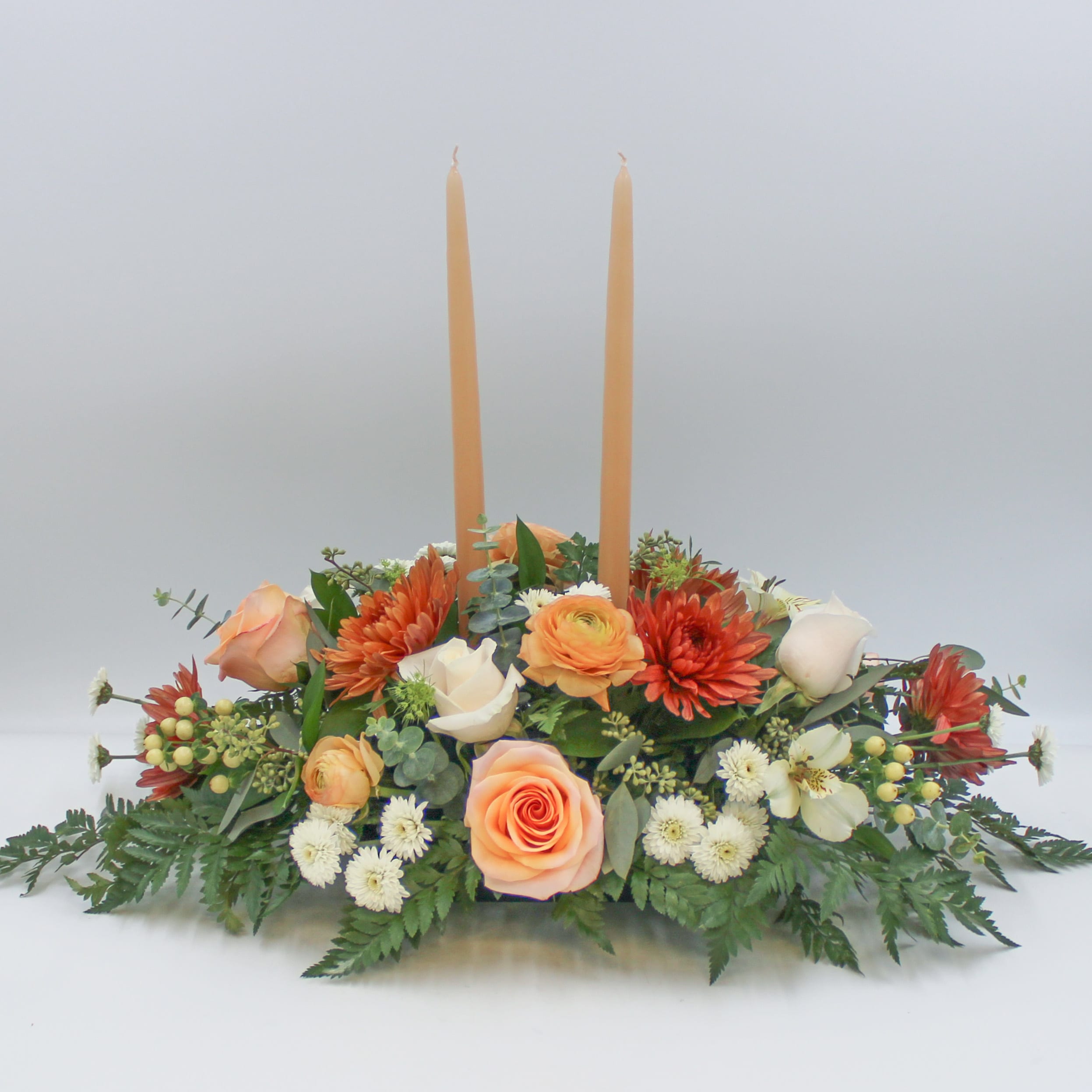 Ginger Spice - Ginger Spice is a traditional long and low centerpiece with beautiful Peach, Bronze and Ivory florals that features Bronze Mums, Peach Roses, Ivory Roses, White Button Mums, Seeded Eucalyptus, Spiral Eucalyptus and more.