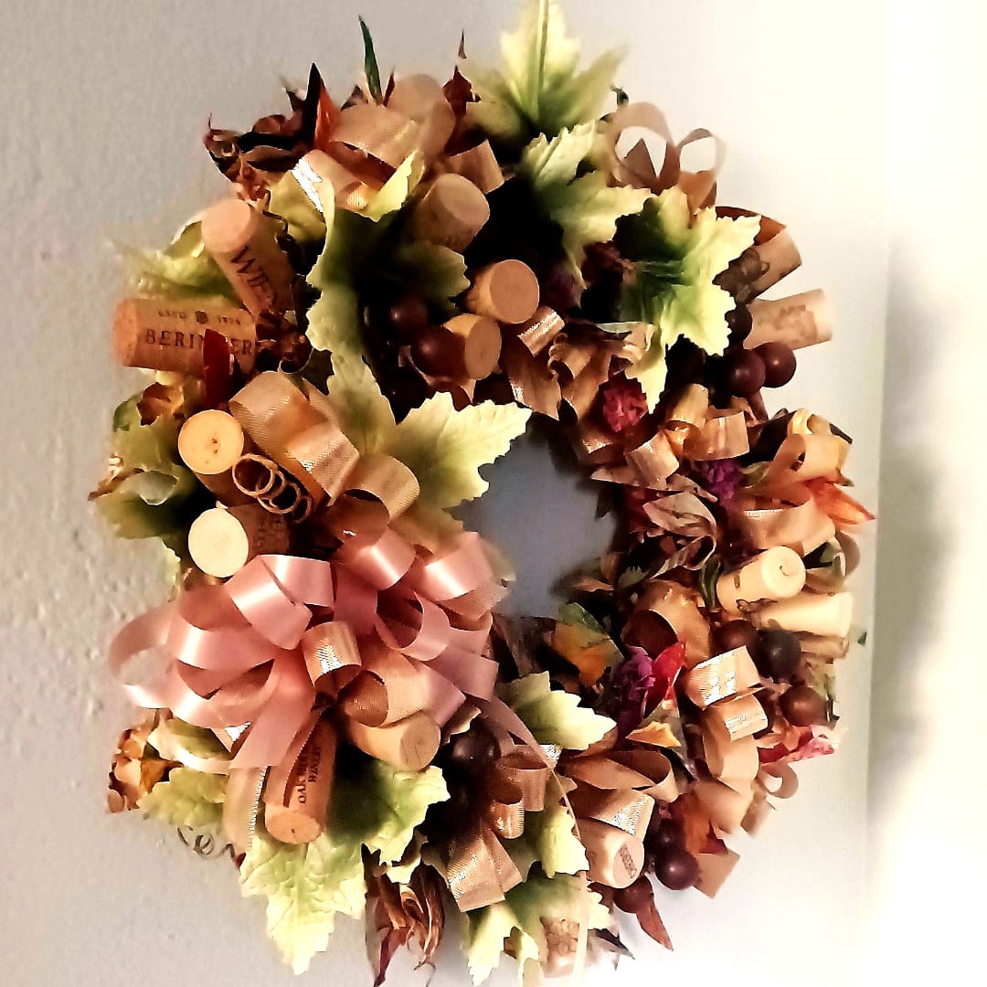 Decorative wreath with ribbon bows and faux leaves on a wall