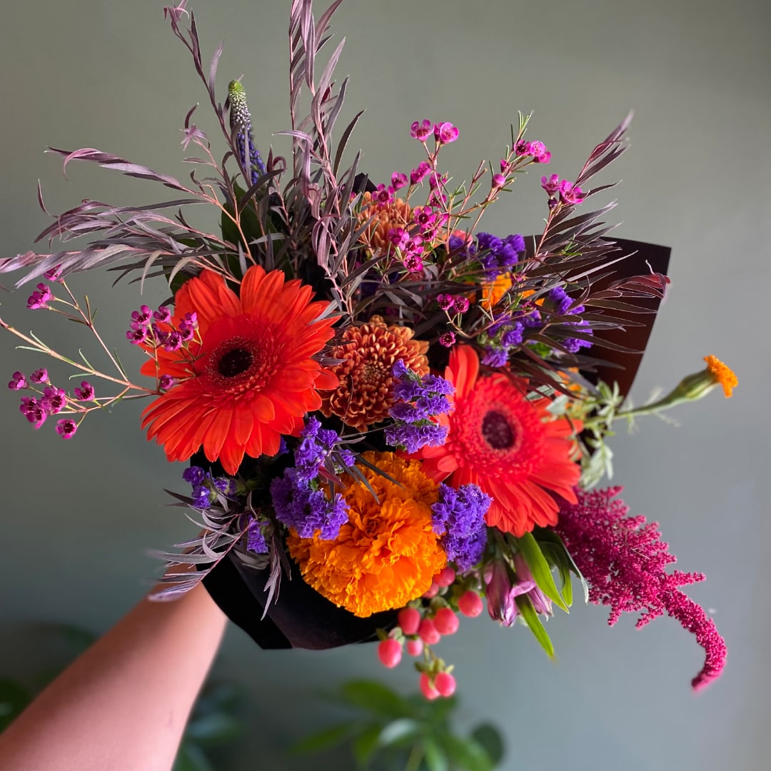 Bright mixed bouquet with gerbera daisies, marigolds, and purple filler flowers