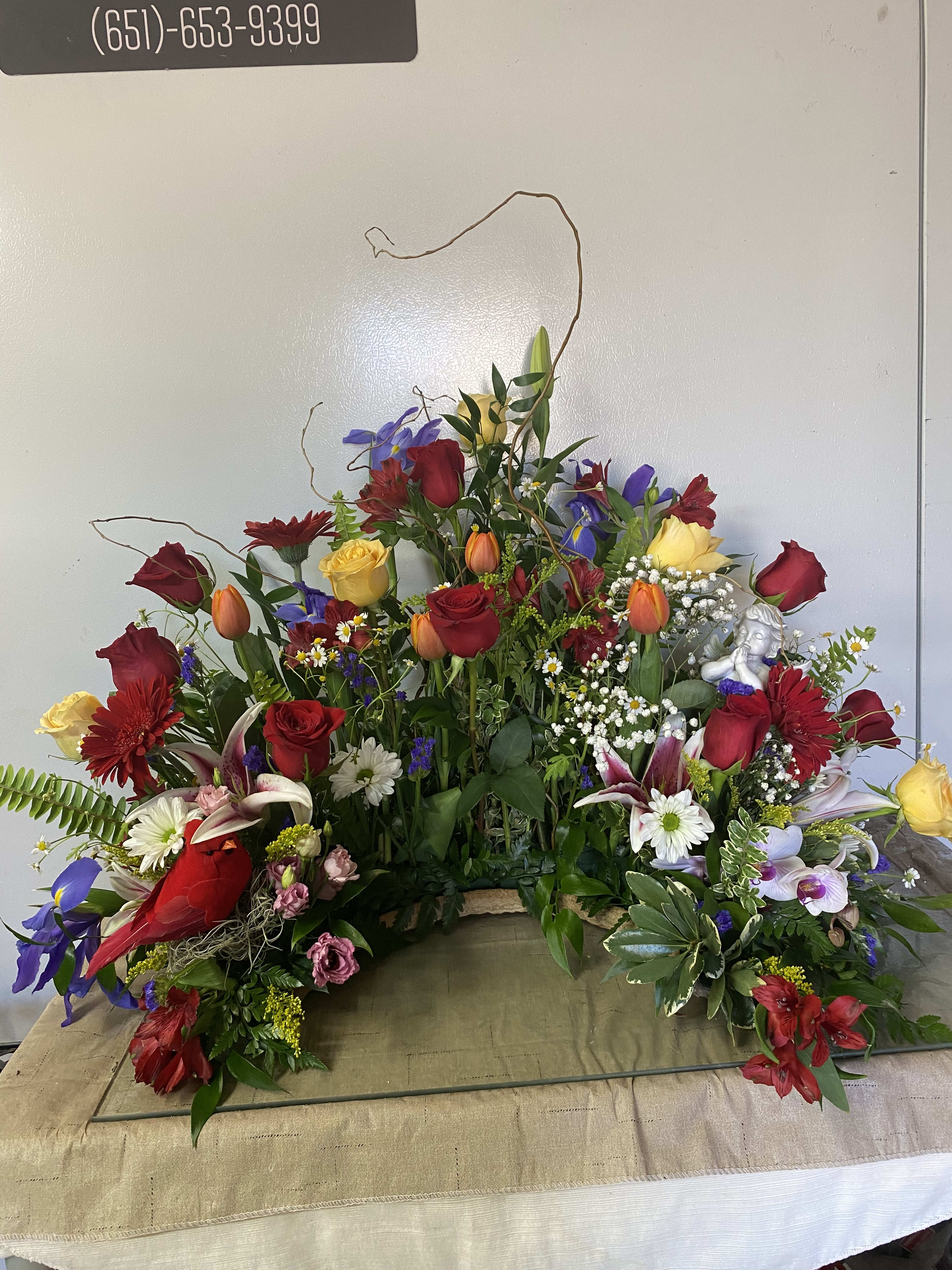 Large mixed floral arrangement with red and yellow roses and lilies