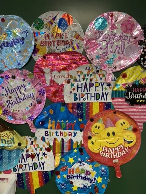 Assorted birthday balloons with colorful printed designs and messages