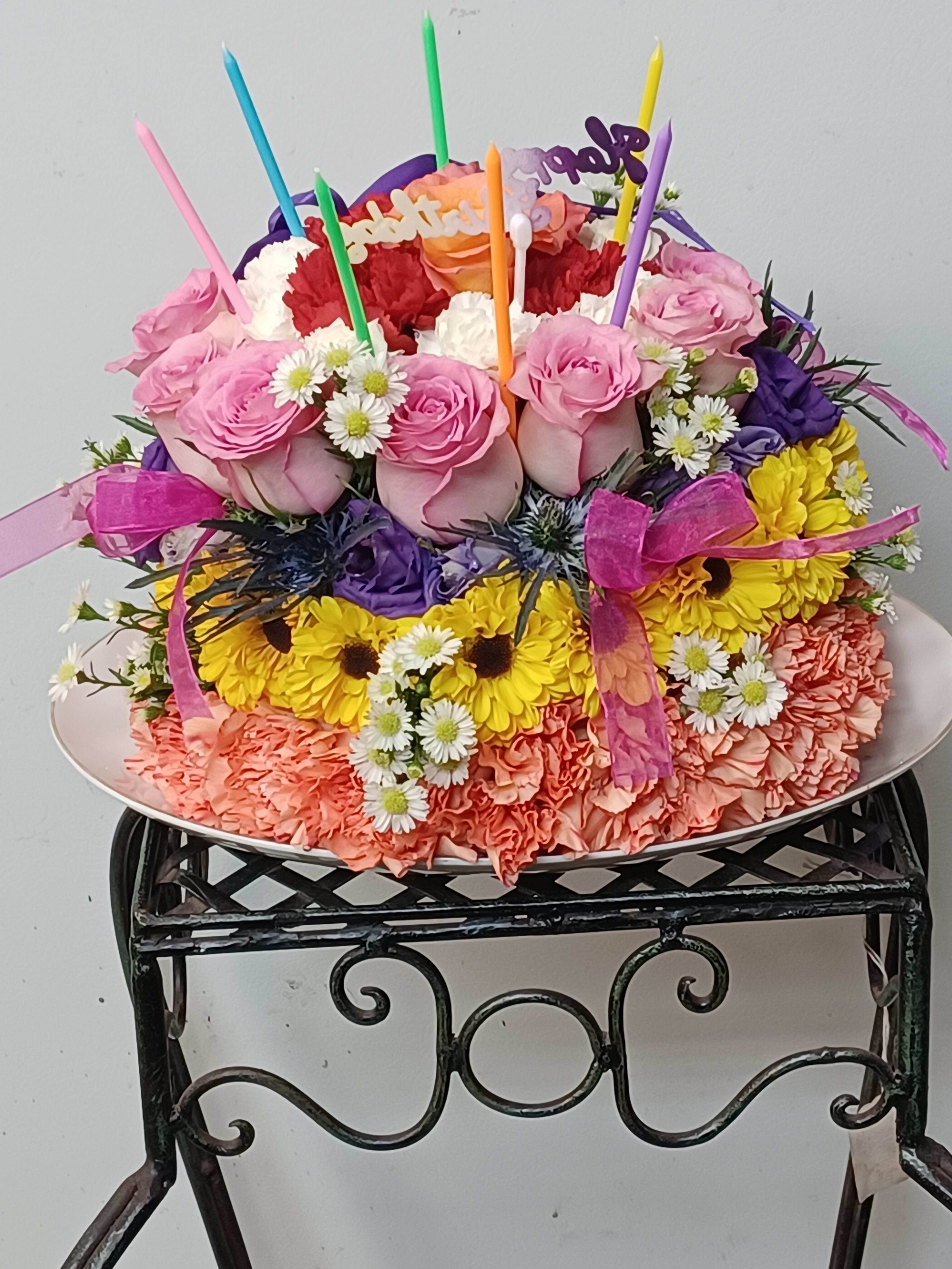 Colorful birthday cake made of flowers with candles