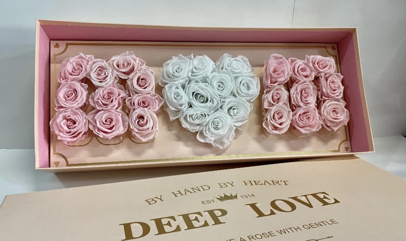 Box of pastel roses arranged in three heart shapes