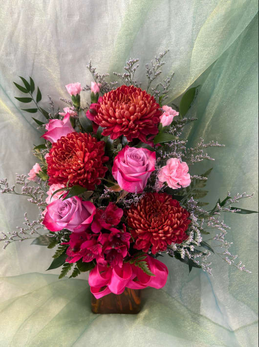 Fall Sunset  - This arrangement encapsulates the essence of the perfect fall evening with its beautiful purples, pinks and dark oranges. It is the perfect arrangement to tell your sweet heart that you care about them, and that they're as beautiful as the sunsets! 