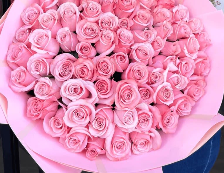 Large bouquet of pink roses wrapped in pink paper