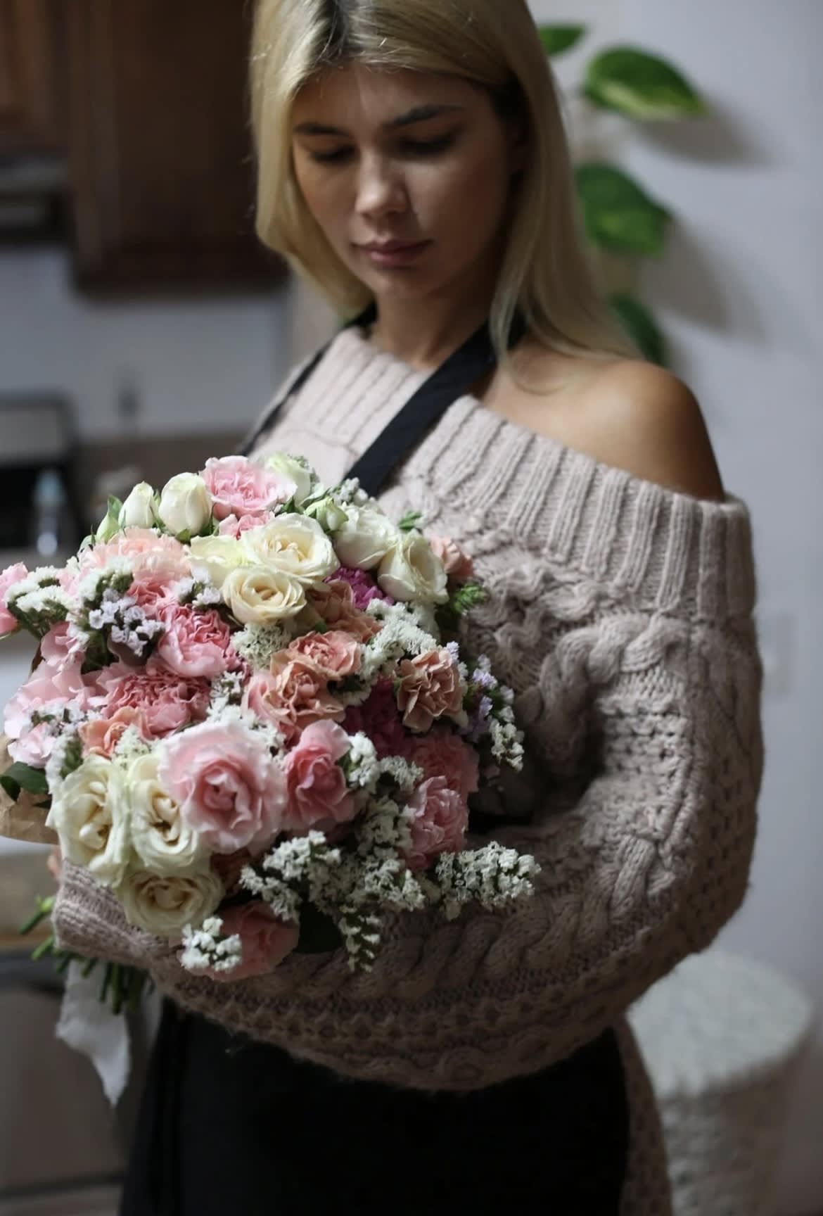 Woman holding a large bouquet of pink and white roses