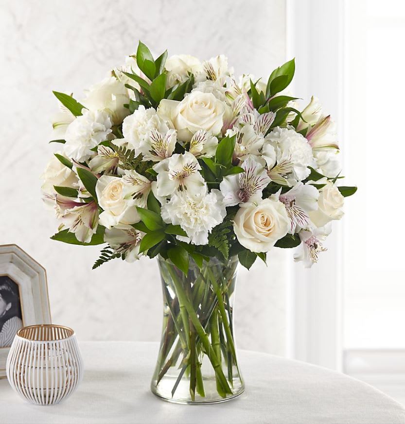 The FTD® Cherished Friend™ Bouquet - The FTD® Cherished Friend™ Bouquet offers comfort and sympathy in the time of grief and loss. Bright white roses and Peruvian lilies are accented by lush greens and gorgeously arranged in a clear glass gathering vase to create a bouquet that will bring peace and show how much you care. GOOD bouquet includes 14 stems. Approximately 18"H x 12"W. BETTER bouquet includes 20 stems. Approximately 19"H x 13"W. BEST bouquet includes 26 stems. Approximately 22"H x 15"W. Your purchase includes a complimentary personalized gift message.