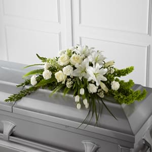 White floral spray on a gray casket