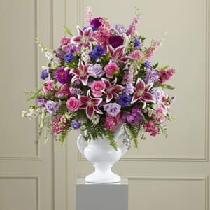 Large mixed bouquet in a white urn vase with pink and purple flowers