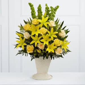 Yellow lilies and cream roses in a white vase