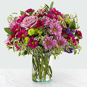 Pink and purple mixed bouquet in a clear glass vase