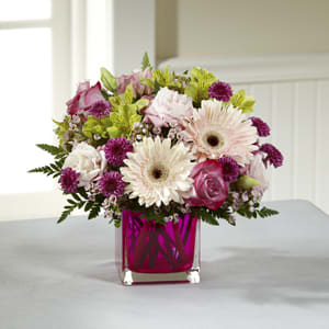 Pink and white flowers in a magenta glass vase