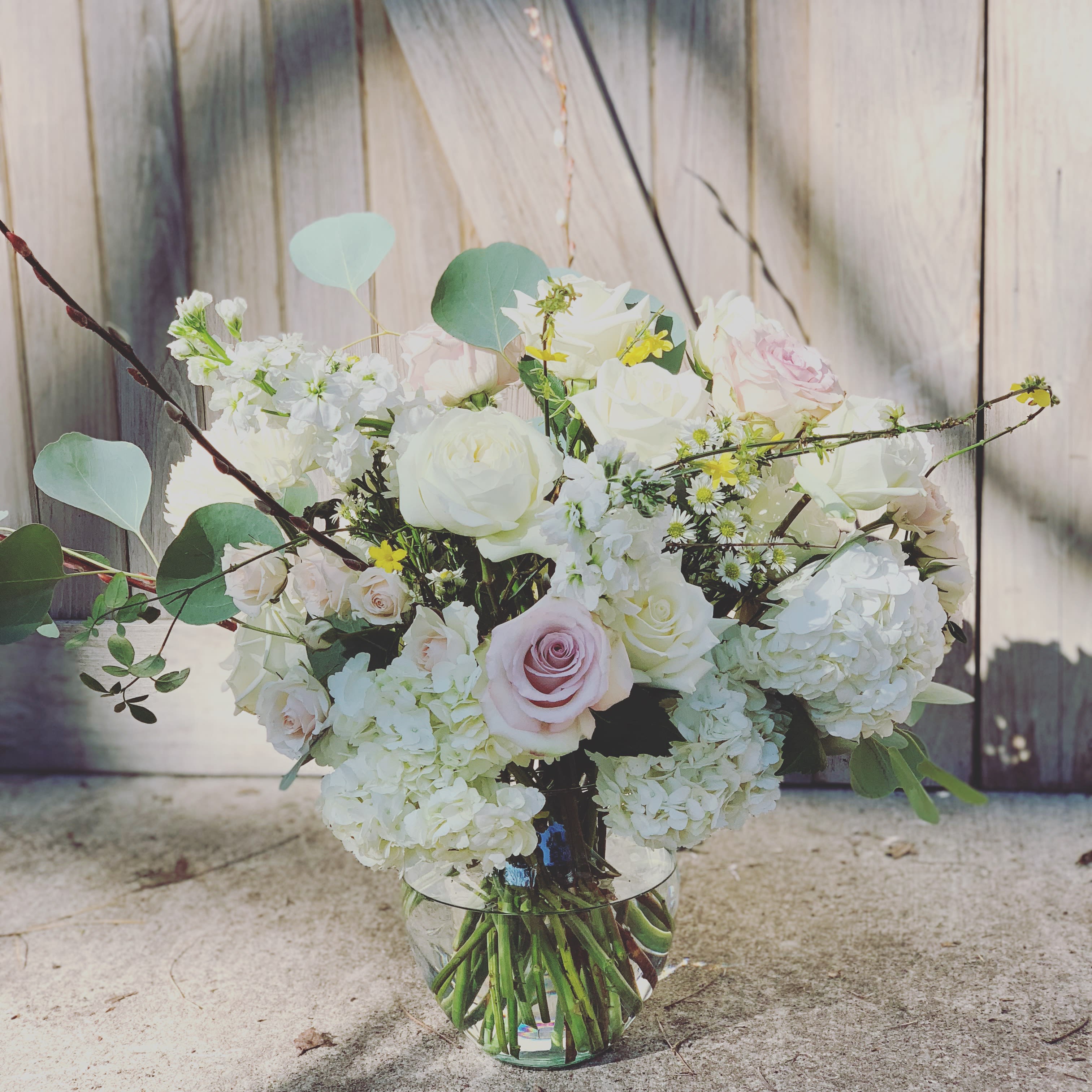 Bouquet of white and pale pink roses in a clear glass vase