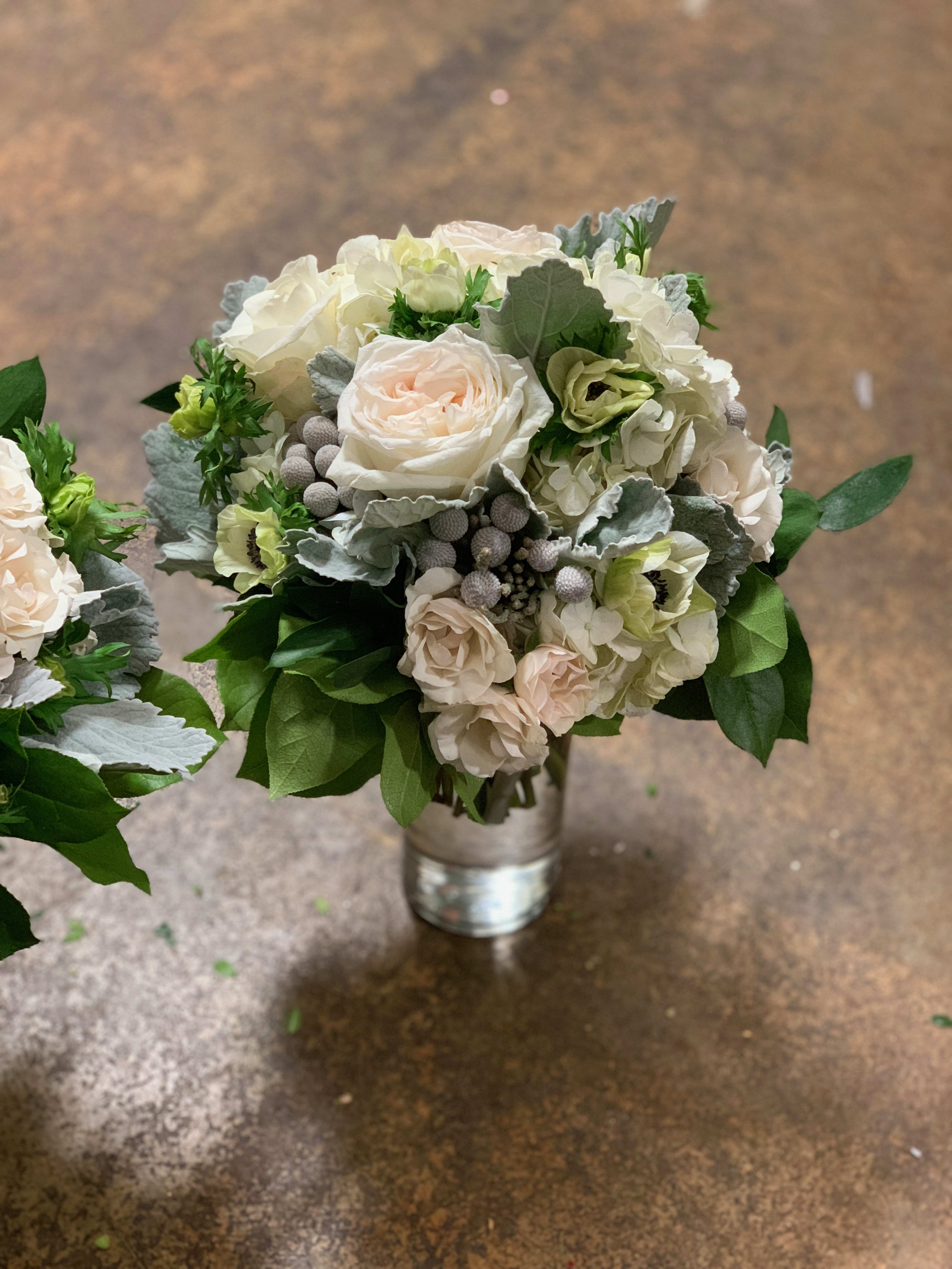 Bouquet of pale roses and white hydrangeas in a metal vase