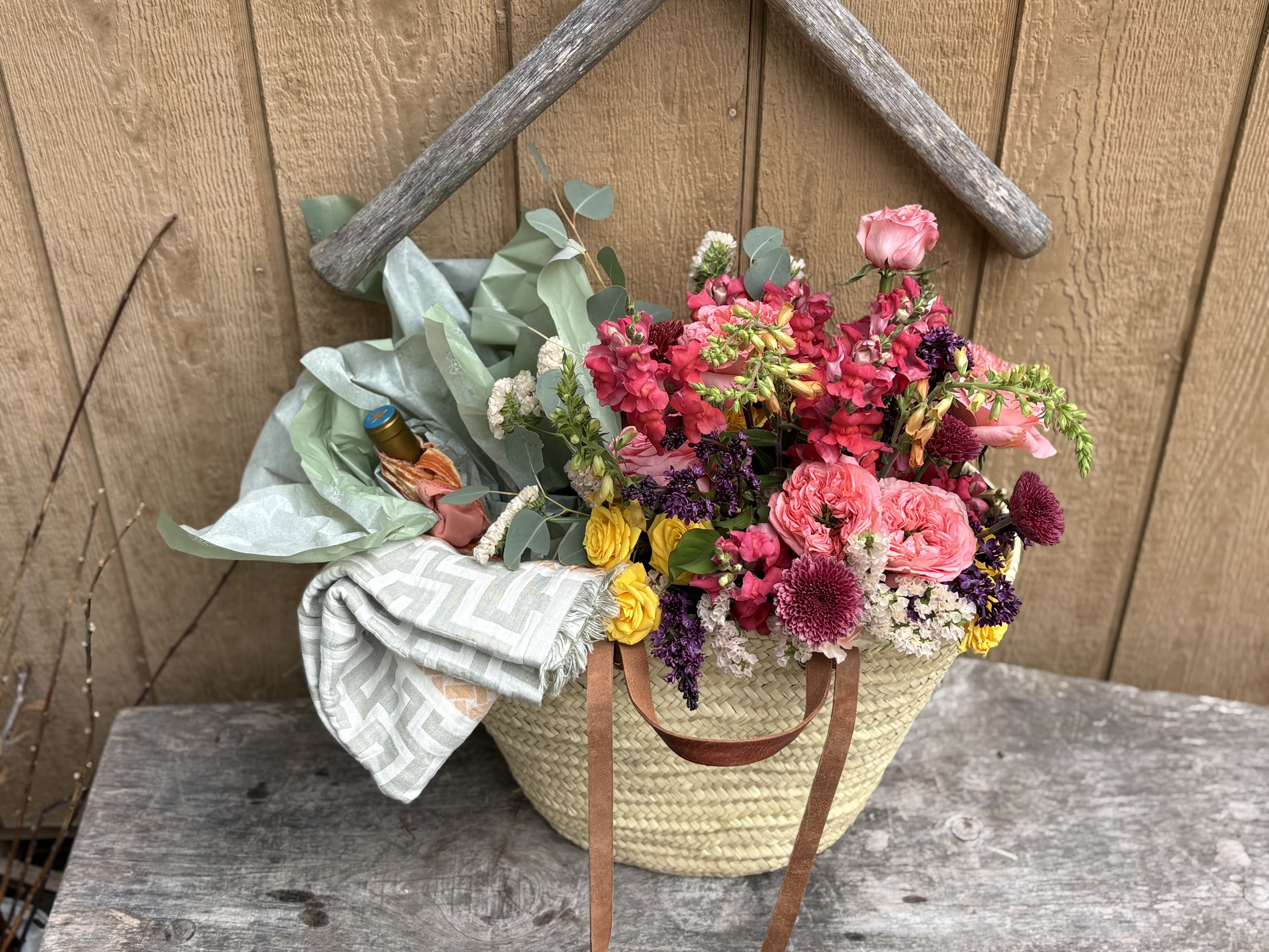 The Bloom &amp; Linen Market Basket - The Bloom &amp; Linen Market Basket is a thoughtfully curated gift designed to feel as beautiful as it is lasting.  Featuring a hand-tied bouquet, a bottle of wine, a premium Greek linen towel, and a handwritten card, each element is intentionally chosen to create a moment of ease, celebration, and quiet luxury. Presented in a market-style basket, it’s a gift that can be enjoyed long after the flowers have faded.  Perfect for honoring, celebrating, or simply giving something meaningful—this is gifting, elevated.  Please indicate your preferred wine selection—Rosé, Red, White, or Sparkling—in the notes section at checkout.