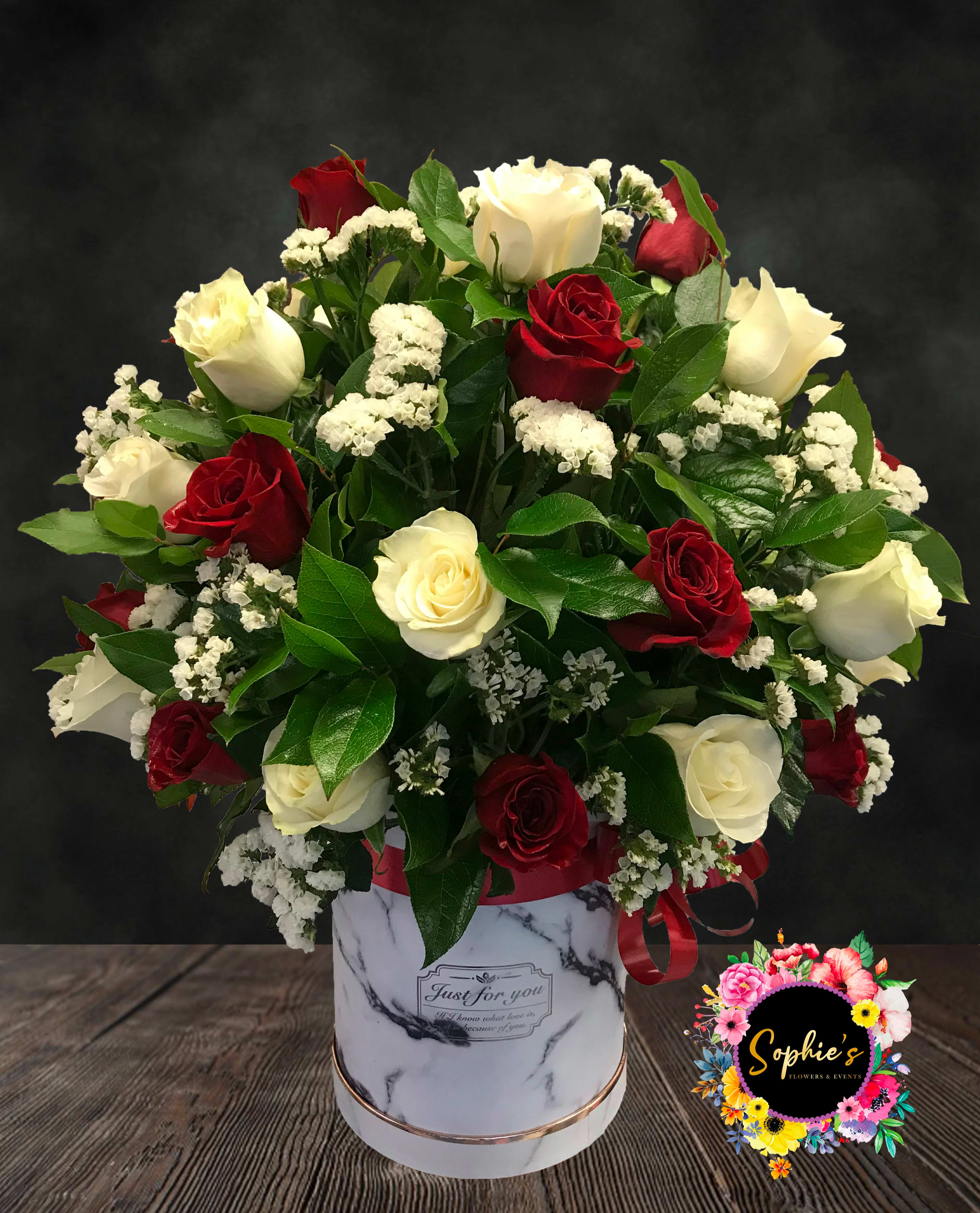 Everyday Elegance Explosion - Red and white rose top hat Arrangement. Very popular year round. Filled with salal lemon leaves, white statice and Israel ruscus. 