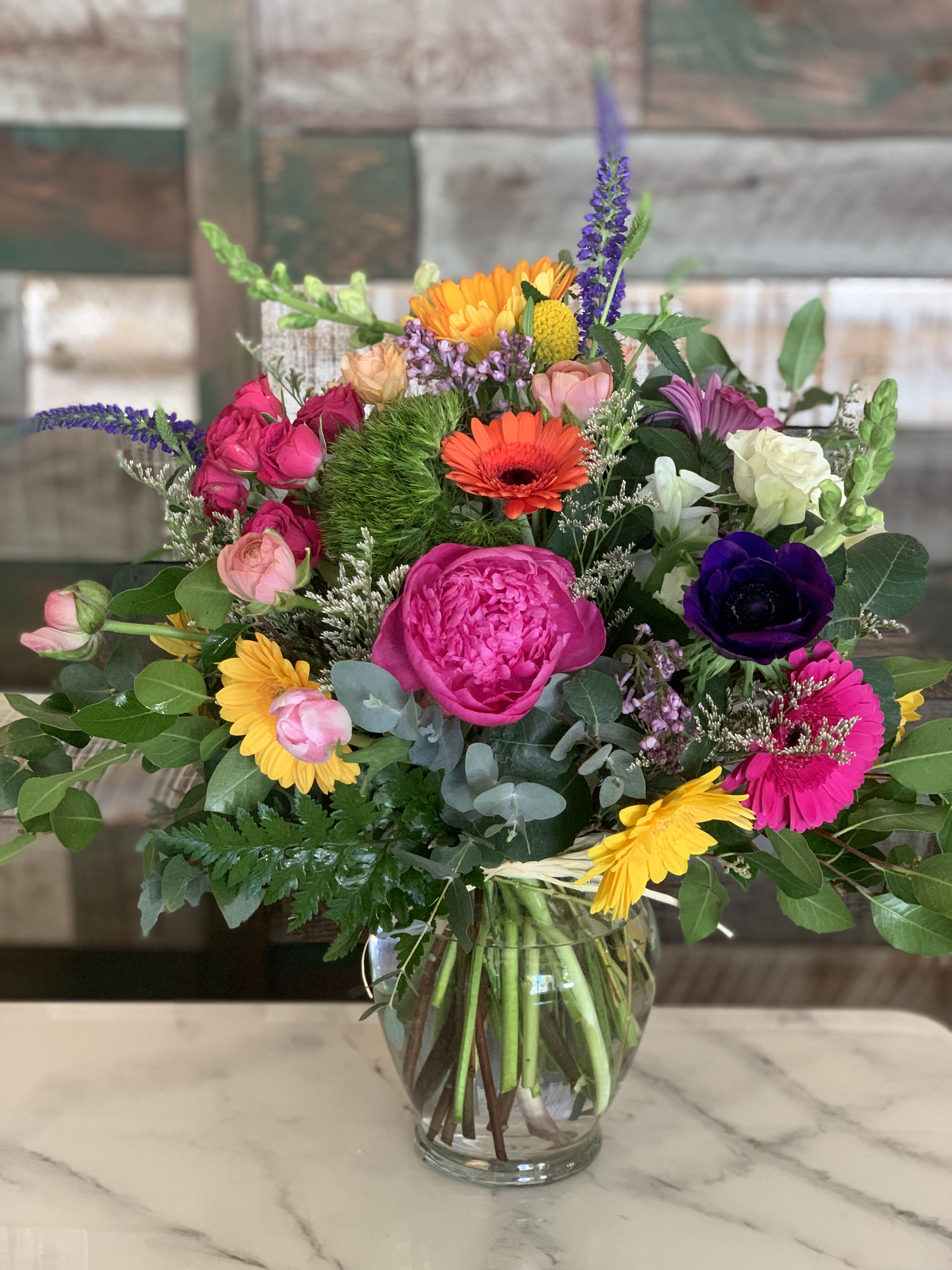Mixed bouquet of bright flowers in a clear glass vase
