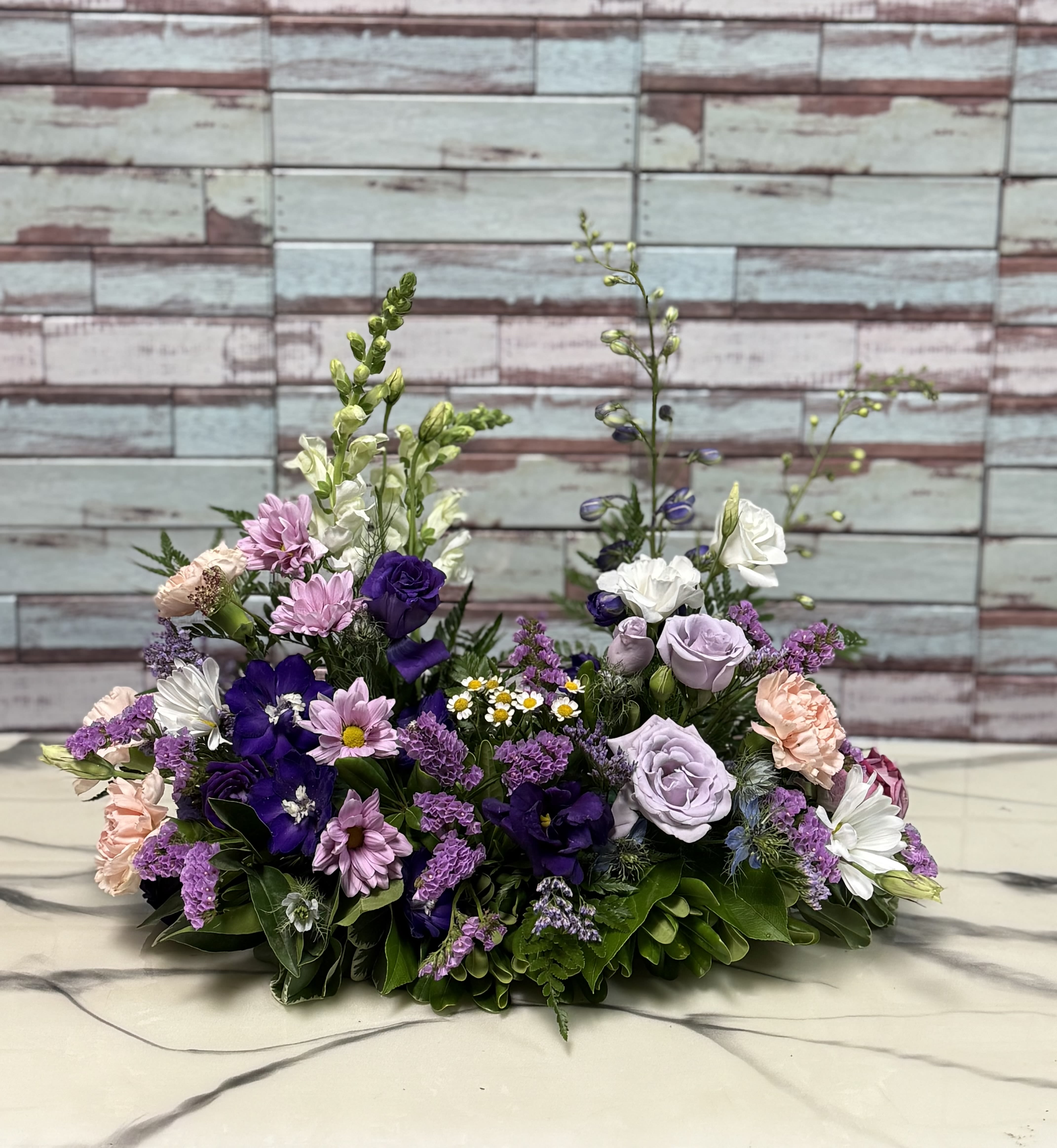 Low floral arrangement with purple, pink, and white blooms