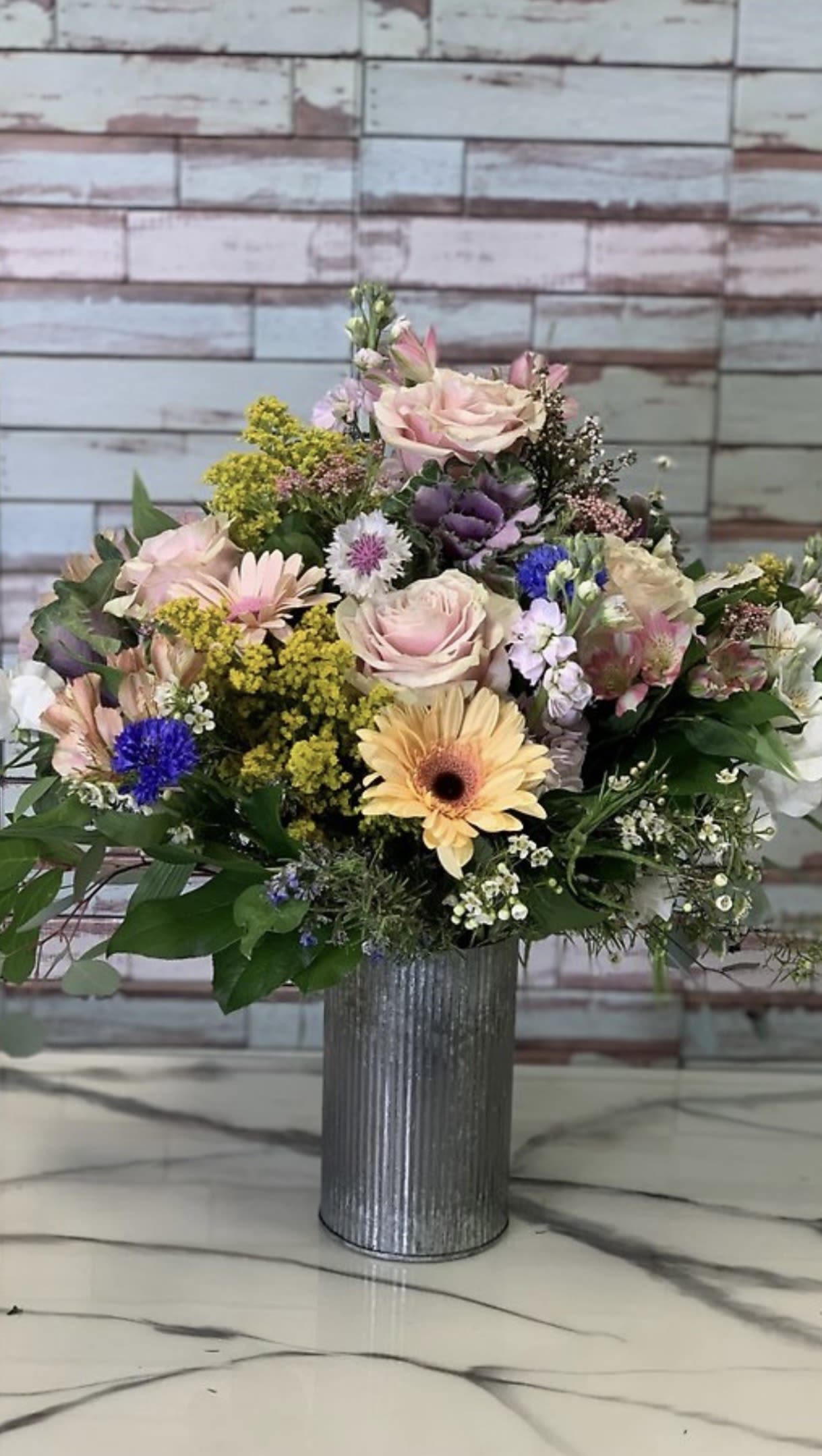 Country Chic - CC is a beautiful assortment of local fresh roses, gerberas, stock, hydrangea, greens and filler. Filled to the brim in a accent decor tin vase (white or silver) sure to make a statement