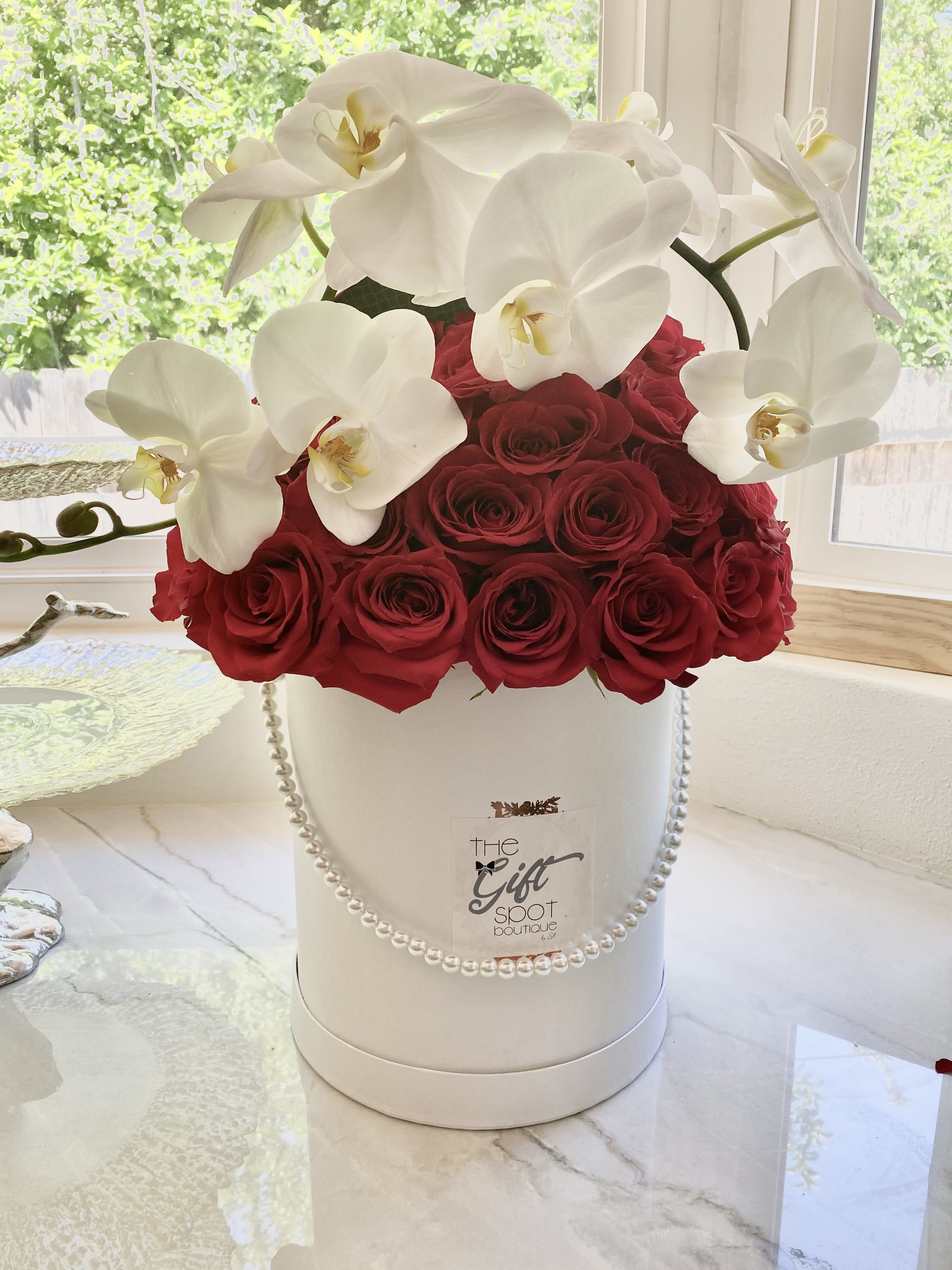 Tall reds and white - Red roses and a bright white orchid.